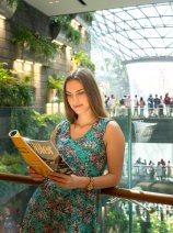 YOTELAIR Singapore Changi Airport - guest reading overlooking waterfall vortex