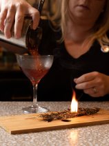 Cocktail being poured with flaming garnish