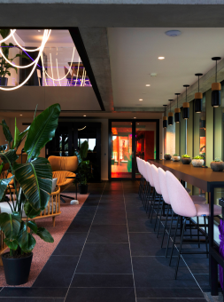 A smart, well decorated hotel bar with black polished floor and white barstools