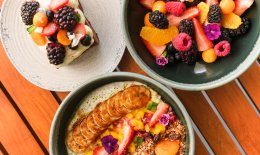 Flat lay image of three brunch dishes with brightly coloured berries