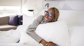 Woman hugging pillow on bed