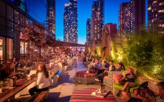 YOTEL New York terrace and bar filled with guests in the evening