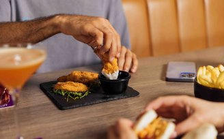 Person dipping chicken nugget into sauce 
