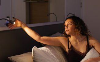 Woman in bed turning off reading light