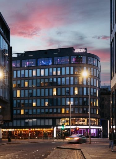 Exterior view of a modern glass building at dusk 