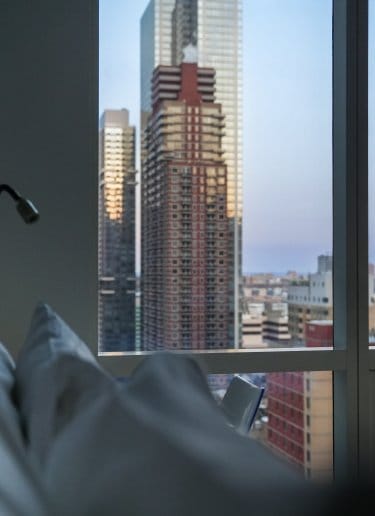 An atmospheric hotel room with sweeping views of New York City
