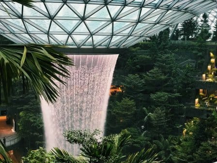 A huge indoor rain vortex surrounded by lush greenery at Singapore Changi Airport
