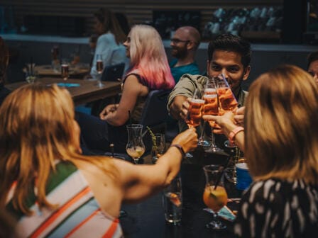 A group of people cheers with their Champagne flutes