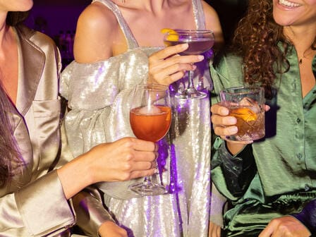 Three girls drinking cocktails