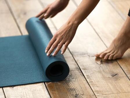 A person unrolls a yago mat 