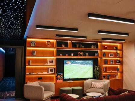A movie plays on a large flatscreen TV in a warm lounge setting