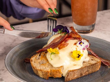 woman cutting into breakfast food