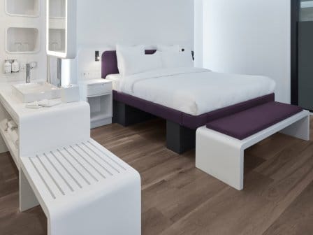 Junir Suite King Size Bed with a end bench, sink & mirror and a luggage stand shown 