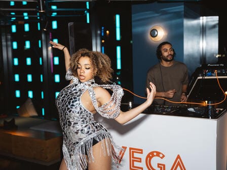 Woman dancing with a DJ in the background