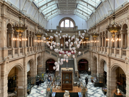 A view of a large museum lobby with ancient stonework, modern decorations and a huge skylight