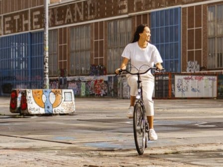 Two people cycling through an eclectic street in Amsterdam