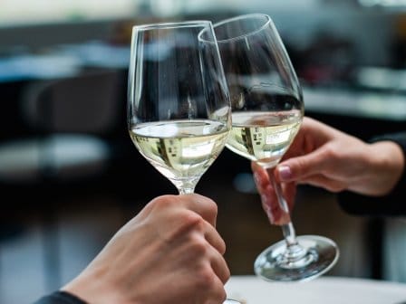 Two wine glasses clinking
