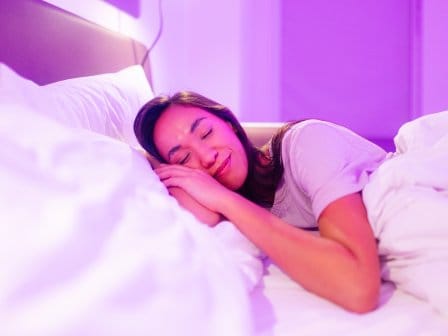 A woman sleeps in a hotel bed