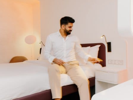 A man in a shirt relaxes in his hotel room