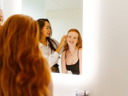 Two girls getting ready in a hotel bathroom