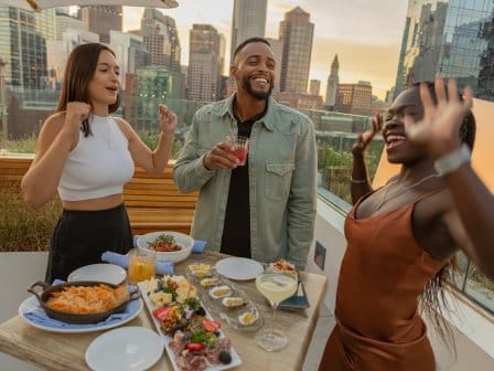 Three friends dance at an outdoor bar