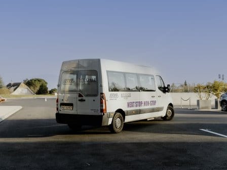 A minibus in a hotel car park. The logo reads, NEXT STOP: NON-STOP