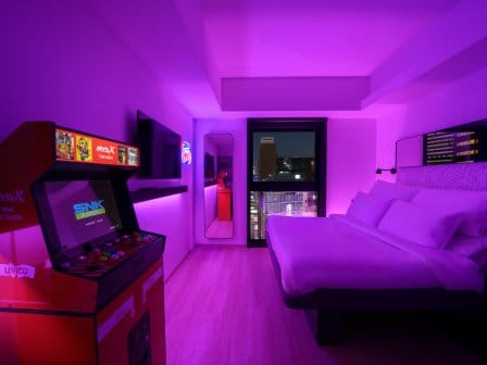 Neon hotel room with an arcade machine 