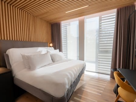A large bed in a clean, airy hotel room