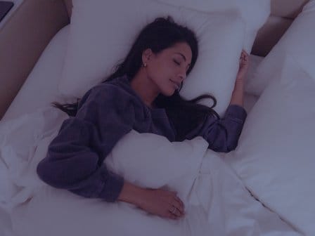A woman lies sound asleep on a bed