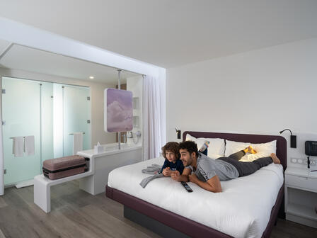 Father and son relax on YOTEL SmartBed inside the First class junior suite