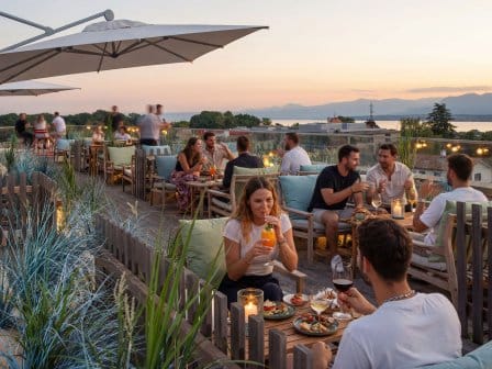 Rooftop terrace showing lots of people eating and drinking as the sun sets