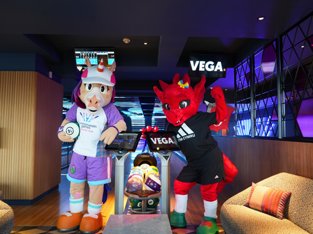 Dragon and horse mascots standing in front of a bowling alley