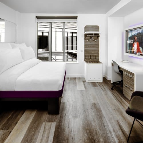 A large hotel suite with purple accents and big windows