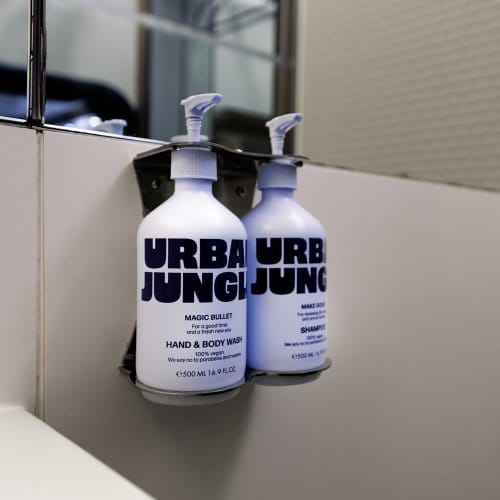 Urban Jungle hand soap hangs on the wall by a bathroom sink
