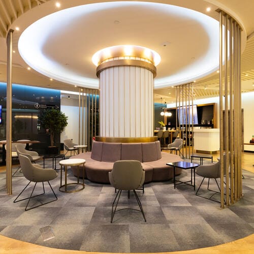 Restaurant and bar lounge with ample seating, and a large white column in the centre
