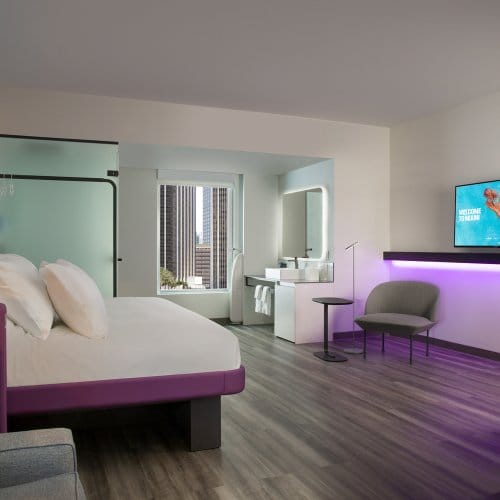 Large hotel room with a flatscreen TV, large bed and mood lighting