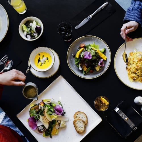 Three friends tuck into a platter of dinner served at a restaurant and bar