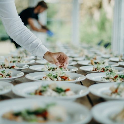 Plates of food being plated up before a large event