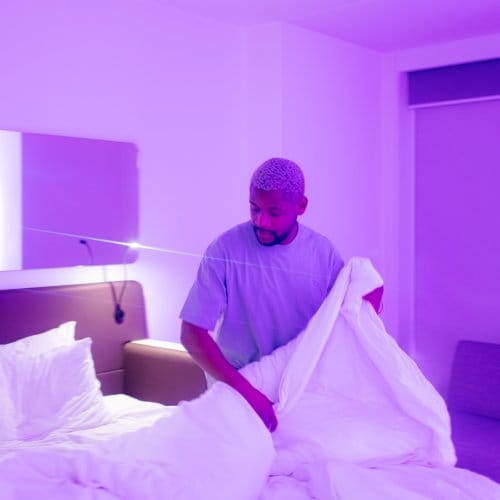 A man relaxes in a clean, modern hotel room