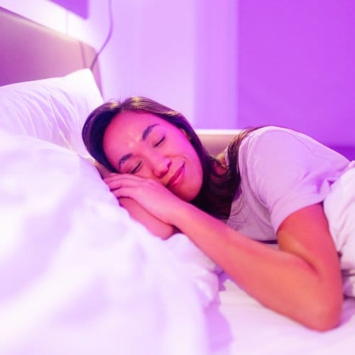 A woman sleeps in a hotel bed