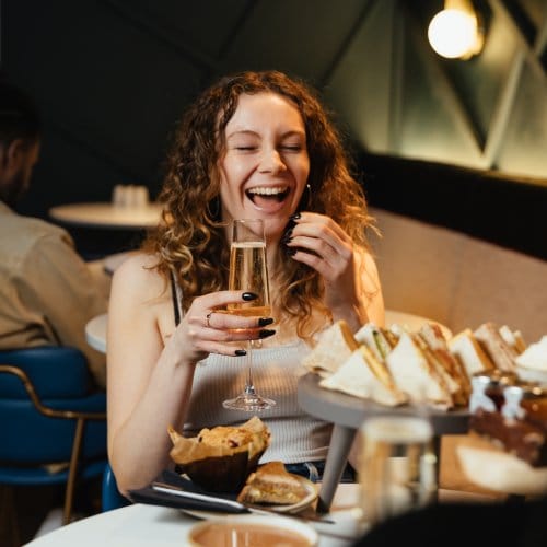 A woman laughs over Champagne