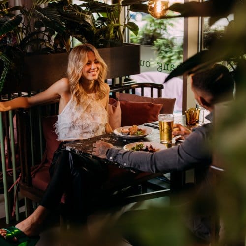 A couple enjoy food & wine in a vibrant hotel restaurant