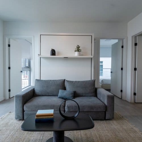 A large hotel suite with a shelf and flatscreen TV