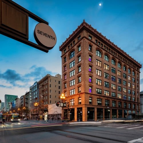 An elegant hotel on the corner of Seventh street, at dusk