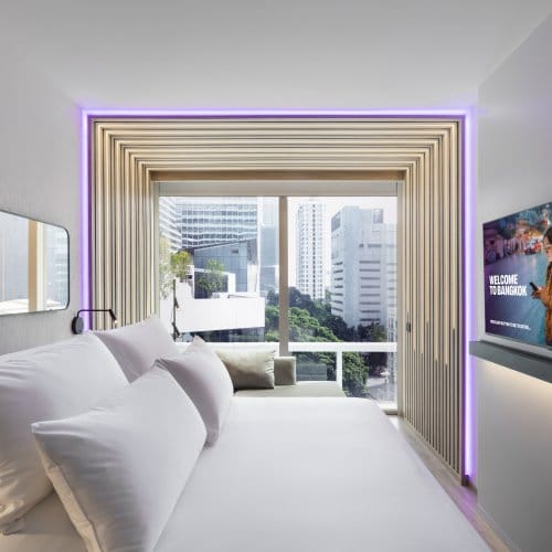 Bedroom with bed in foreground and city view