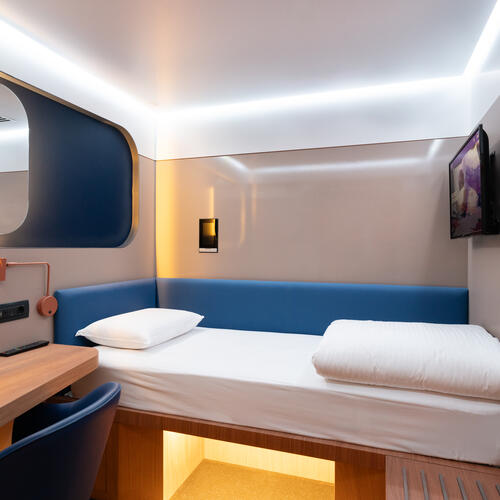 YOTEL Istanbul Airside Recharge Cabins shows single bed, HDTV and working desk