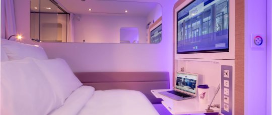 YOTELAIR Paris CDG cabin with pull-out desk and SmartTV