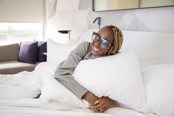 Woman hugging pillow on bed