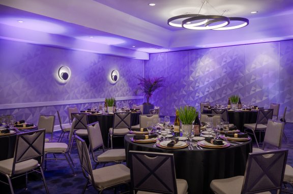 Round tables with plenty of seating. The walls are purple. 