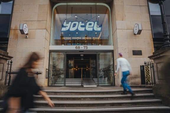 People walking by the front entrance of YOTEL Edinburgh
